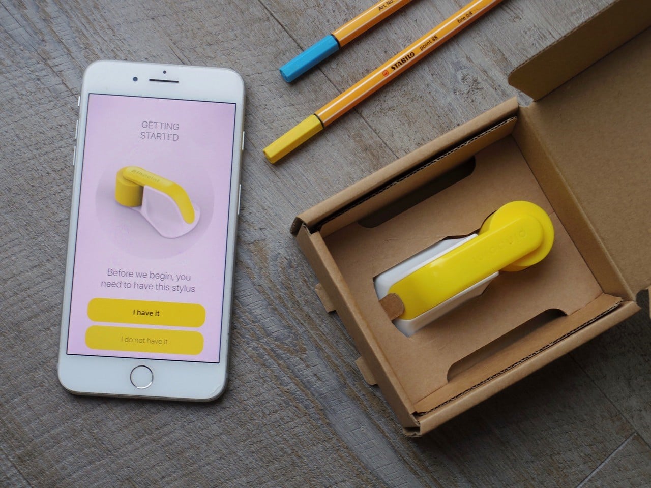 foot measurement device next to an iphone with the app for the device on the screen